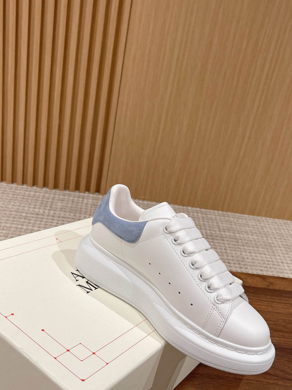 White leather lace-up sneaker with light blue collar panel and stitched toe