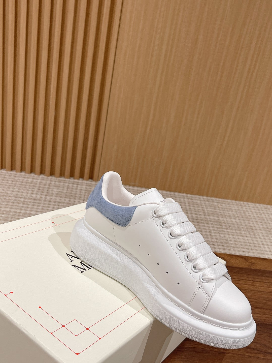 White leather lace-up sneaker with light blue collar panel and stitched toe