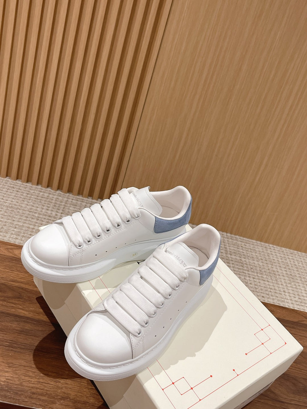 White leather lace-up sneakers with light blue heel trim and padded collar
