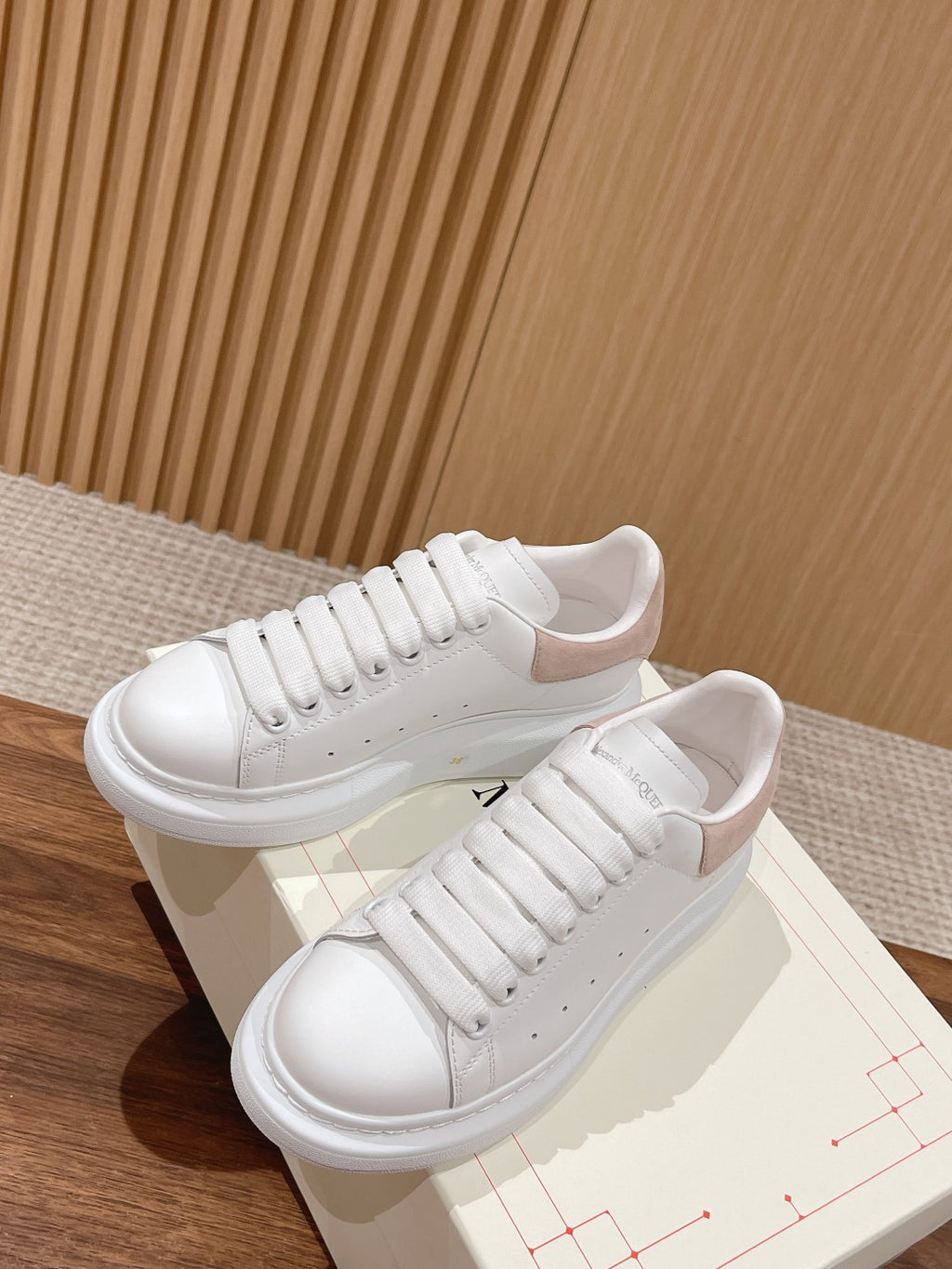 White leather low-top sneakers with lace-up front and chunky outsole