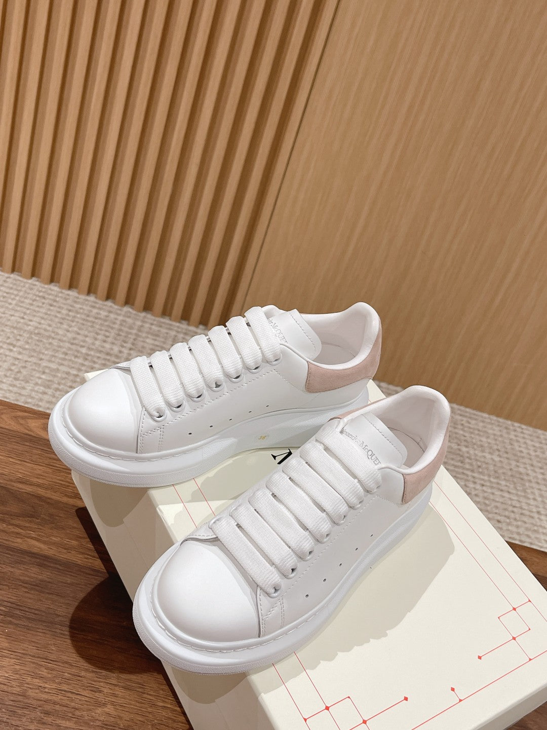 White leather low-top sneakers with lace-up front and chunky outsole