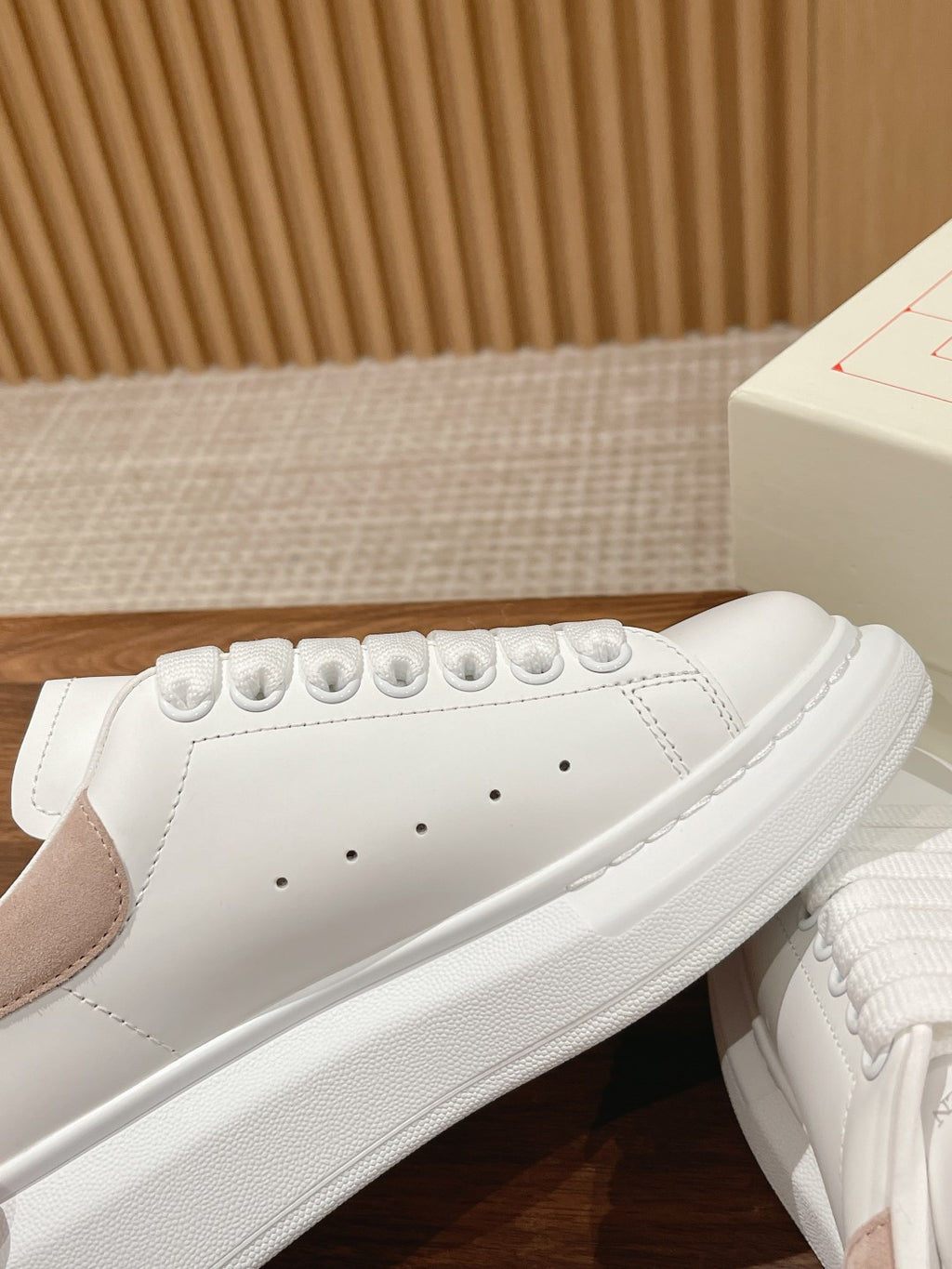 Alexander McQueen white leather sneaker side view with perforated toe and lace eyelets