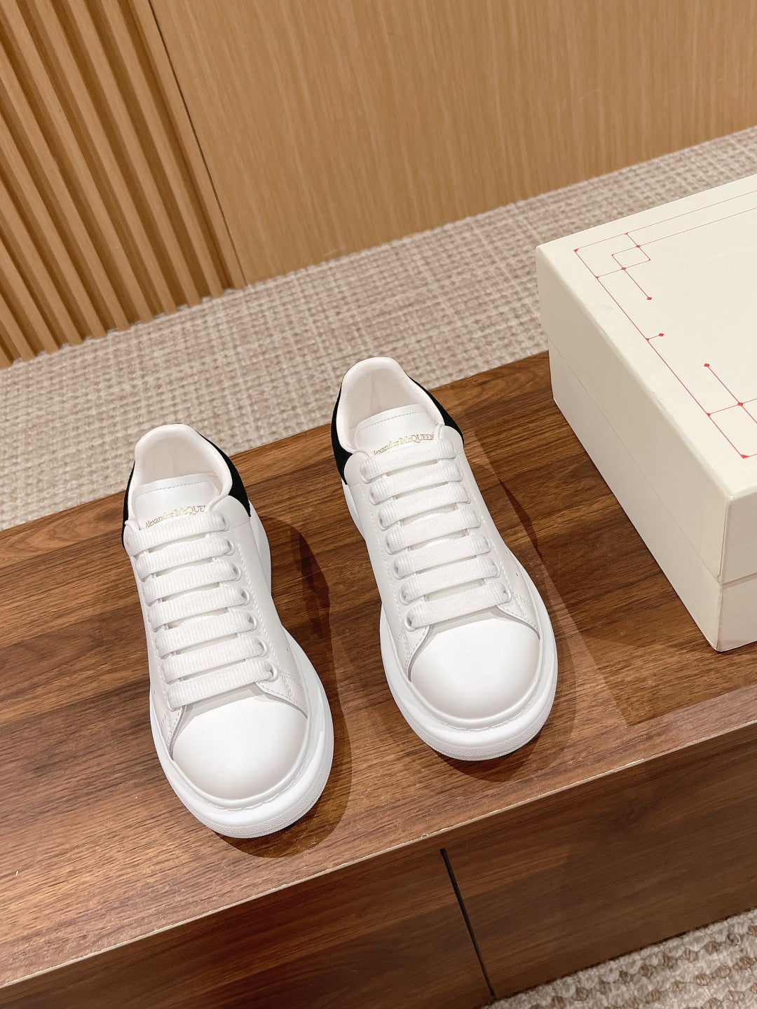 Alexander McQueen white lace-up sneakers with black heel accents, pair view