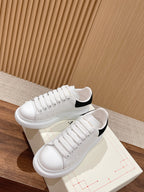 Alexander McQueen white sneakers with black collar trim and lace-up closure