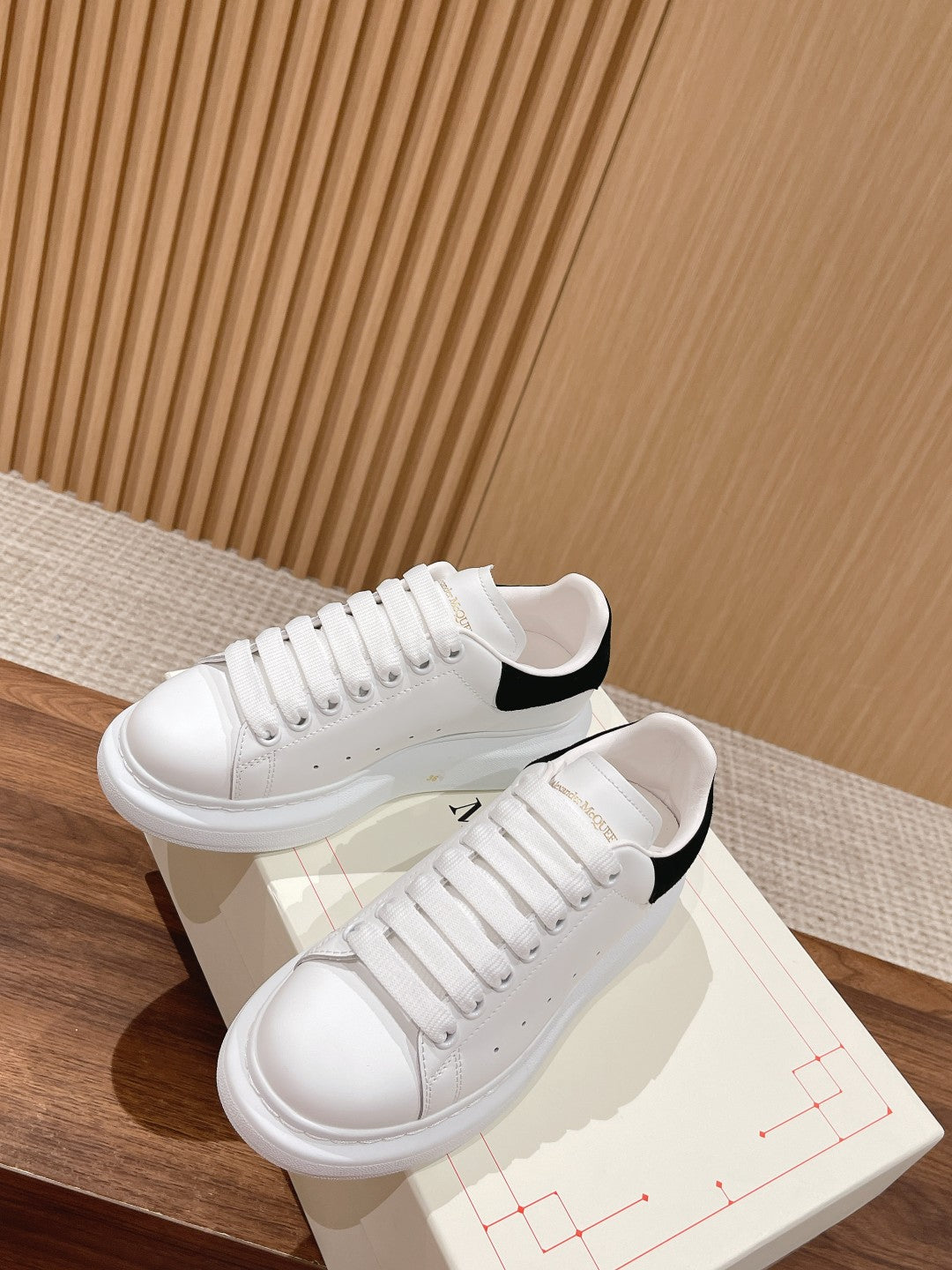 Alexander McQueen white sneakers with black collar trim and lace-up closure