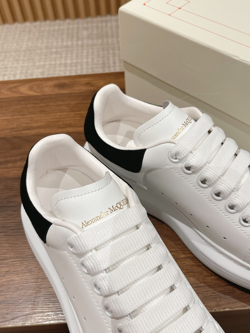 Alexander McQueen white sneakers showing padded interior and black heel lining