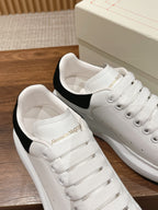 Alexander McQueen white sneakers showing padded interior and black heel lining