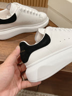 Alexander McQueen white sneaker with black heel tab and matching lace-up details