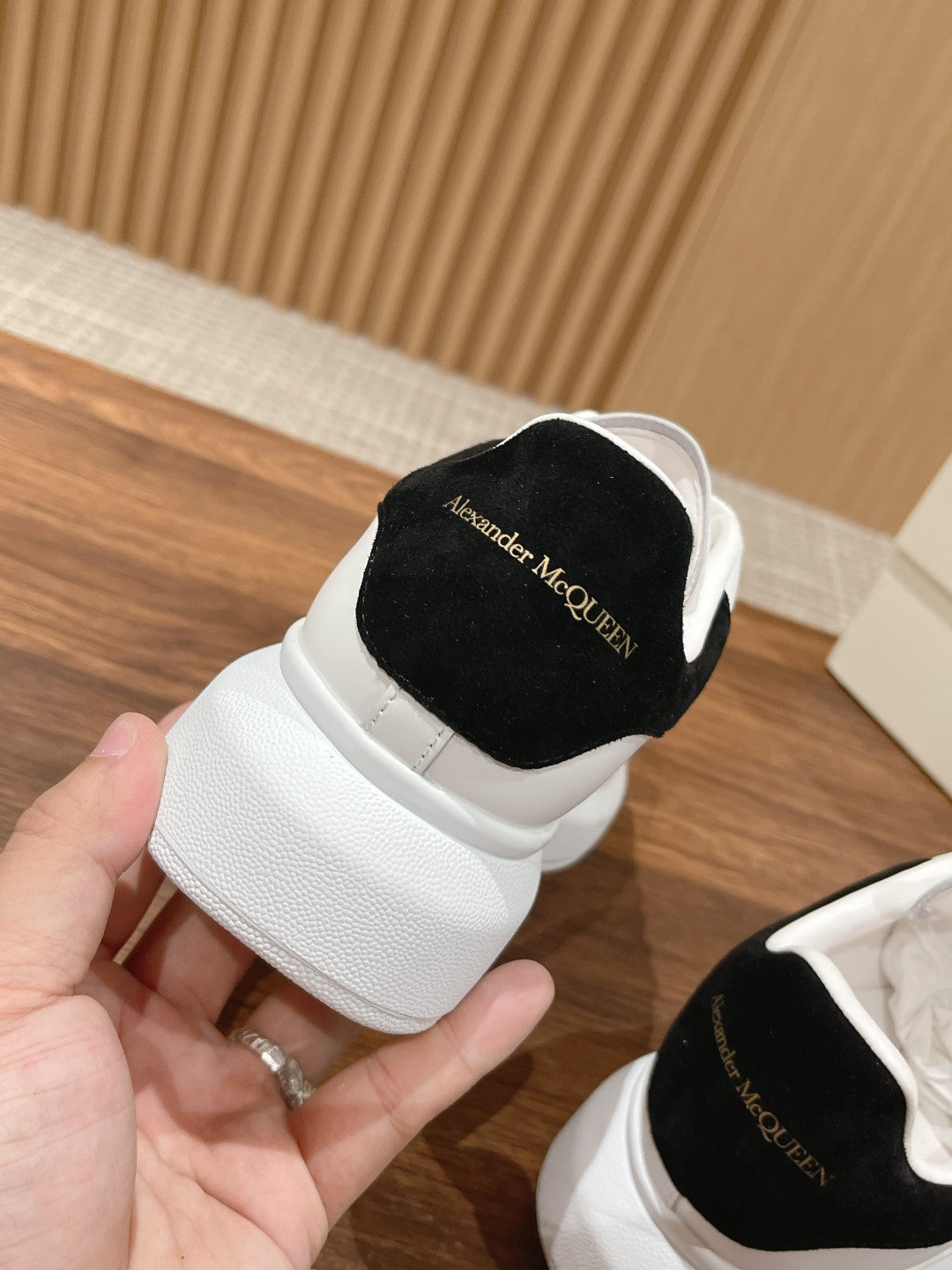 Alexander McQueen white sneaker with black back panel and stitched logo