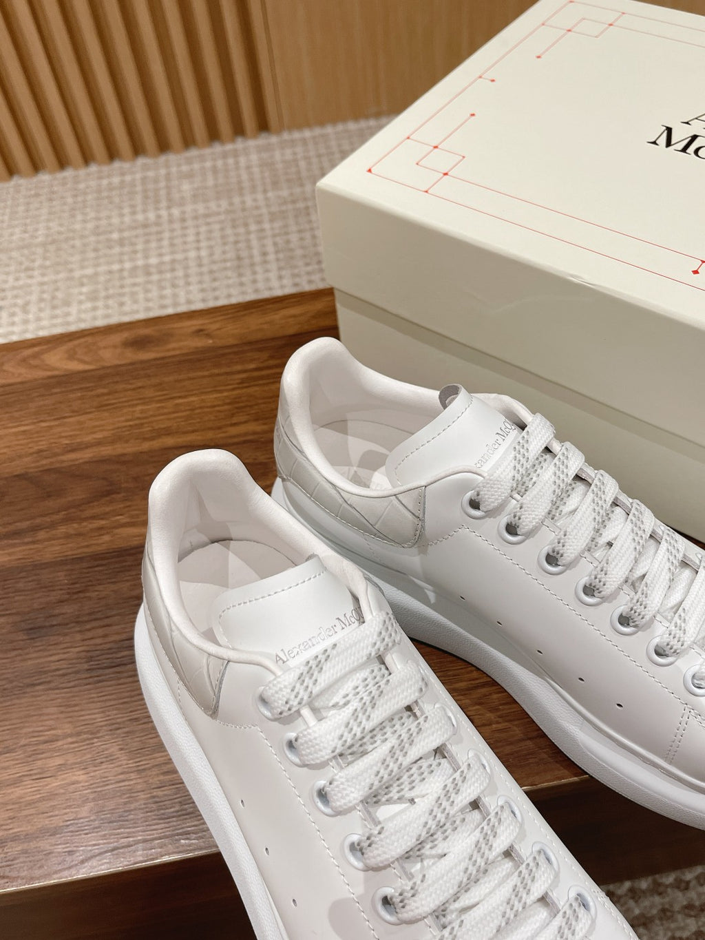 White leather sneakers with lace-up front, close near-side view