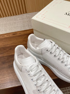 White leather sneakers with lace-up front, close near-side view
