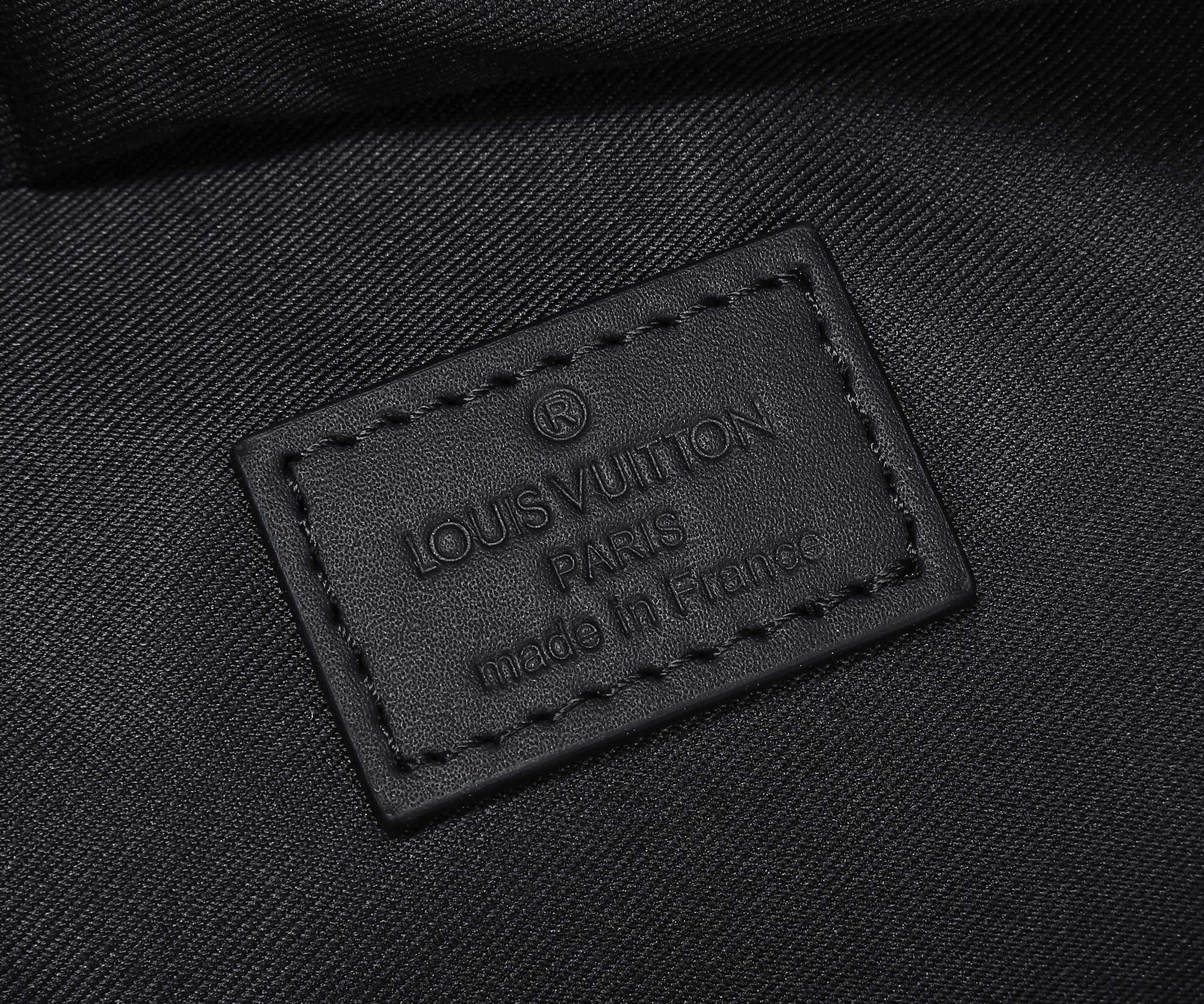 Black fabric inner label on Louis Vuitton bag reading “LouisVuitton Paris”