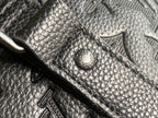 Louis Vuitton duffel bag leather patch with circular logo on dark grained leather