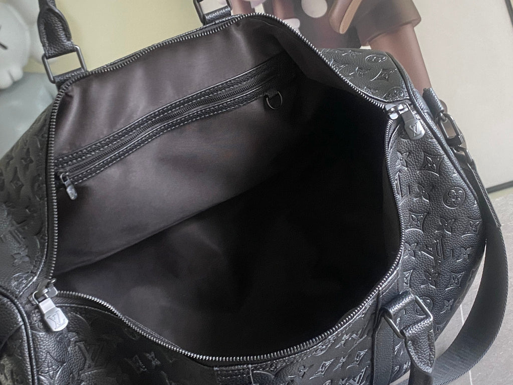 Louis Vuitton duffel bag interior opening with black lining and zipper pocket