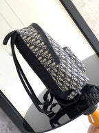 Men's Dior backpack side view with adjustable shoulder strap and black zip pocket