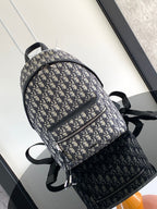 Men's Dior monogram backpack with top handle, adjustable shoulder straps, zip closure.