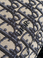 Dior monogram backpack fabric close-up with metal zipper pulls.