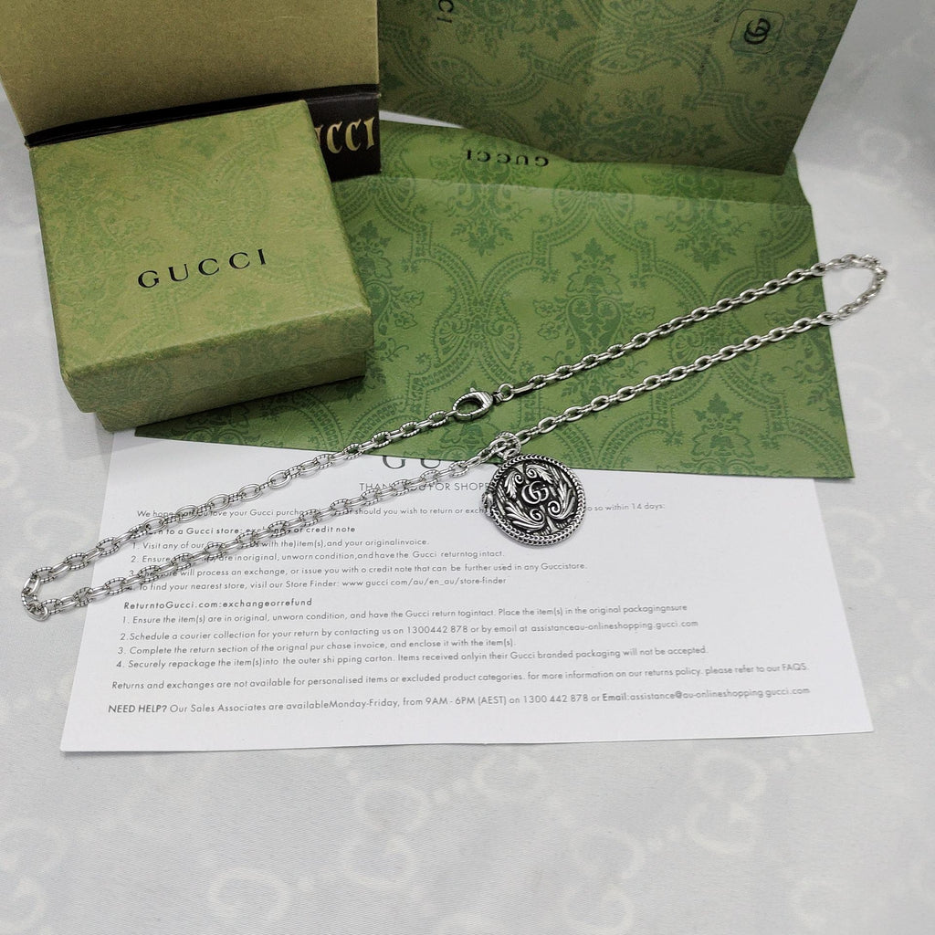 Silver-tone pendant necklace with round logo medallion and chain links