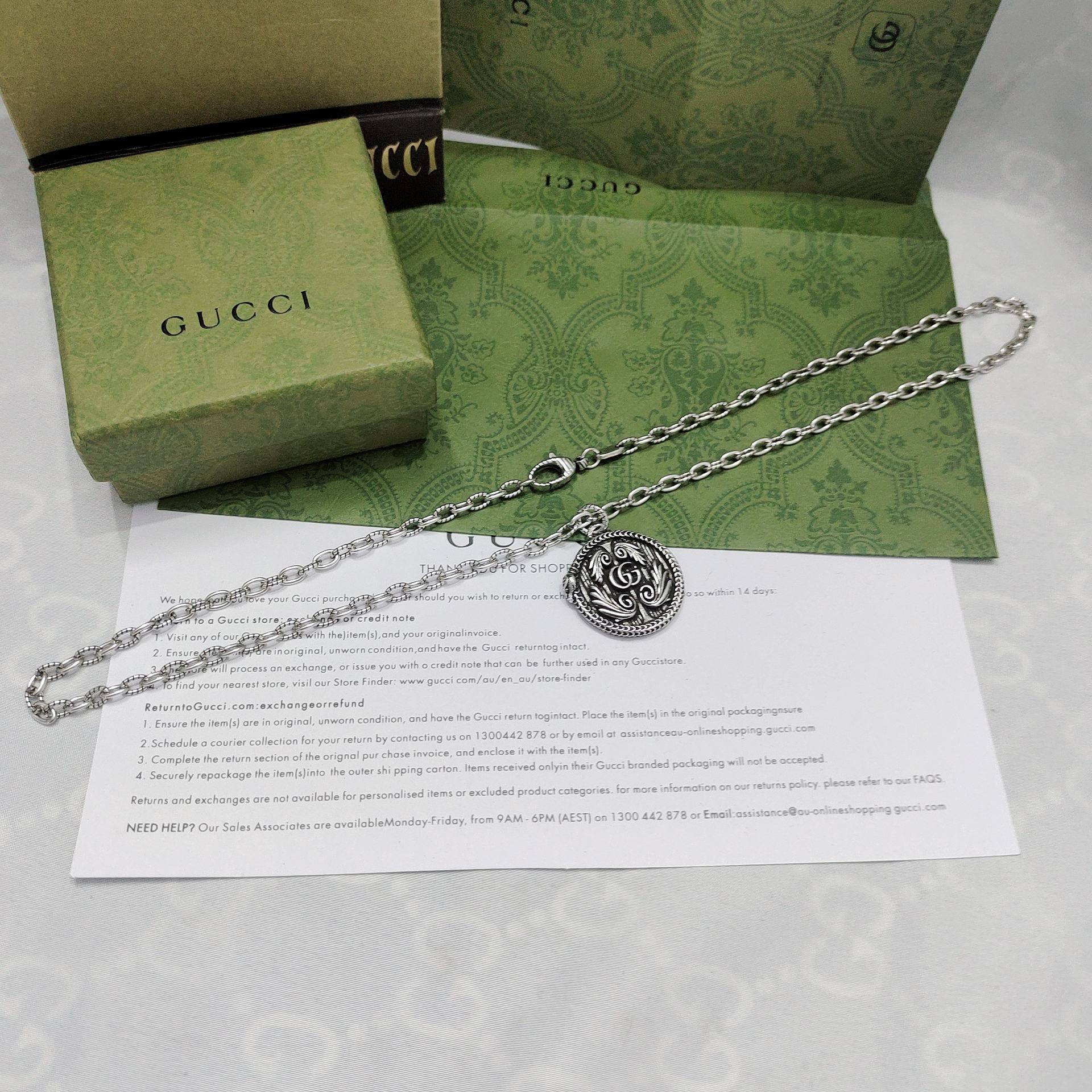 Silver-tone pendant necklace with round logo medallion and chain links