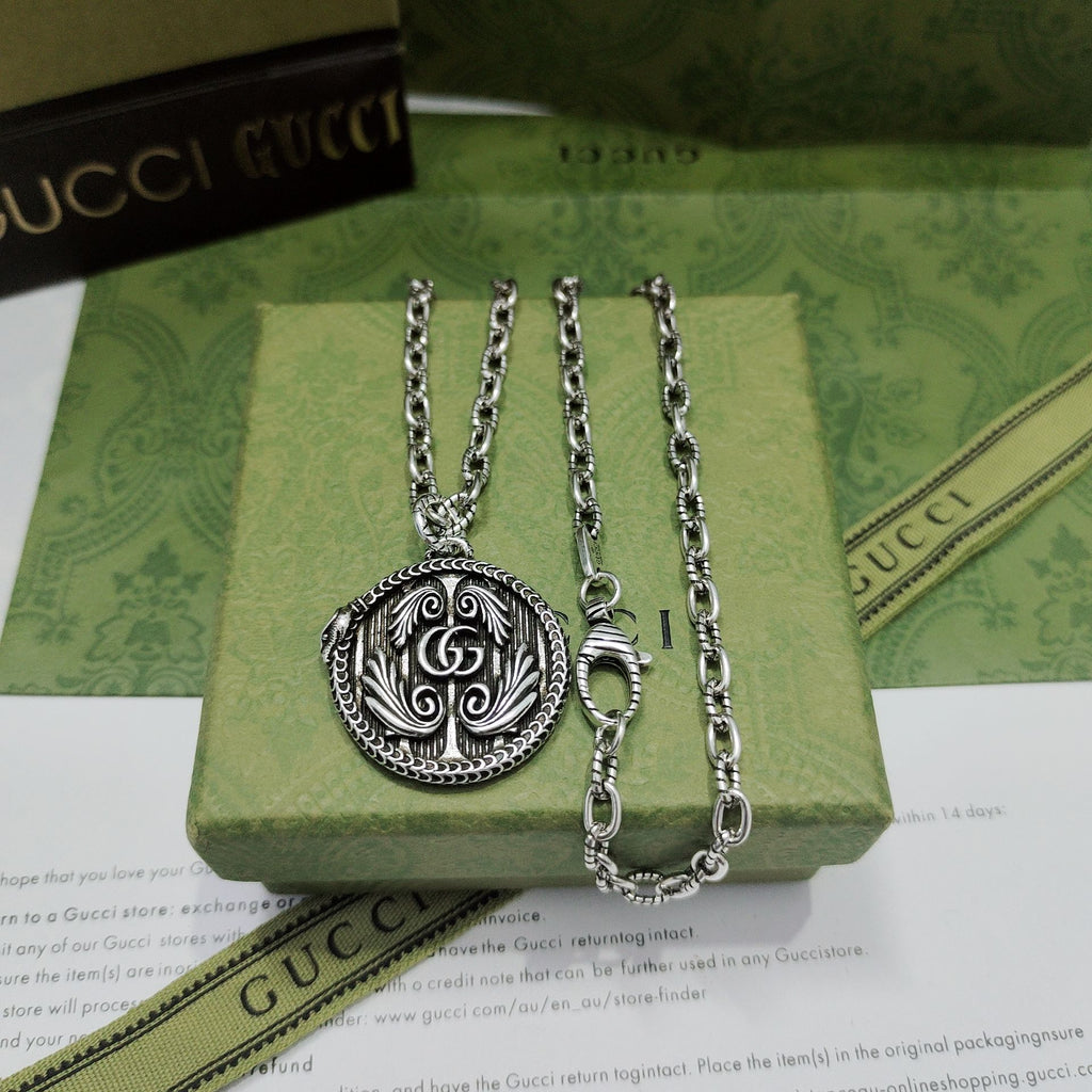 Set of silver-tone pendant necklaces with round logo medallions and chain links