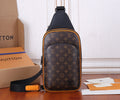 Louis Vuitton monogram sling bag with black strap and orange trim, front view.