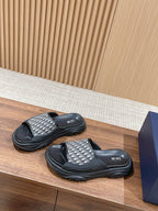 Dior monogram slide sandals, black and silver patterned strap, side view on display