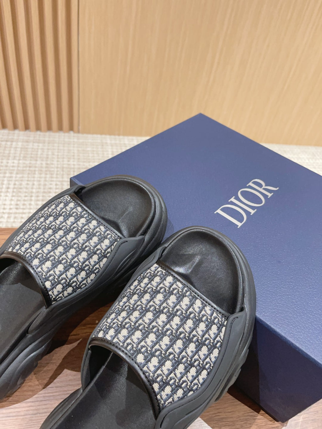 Dior monogram slide sandals with black strap and patterned band, on Dior shoebox
