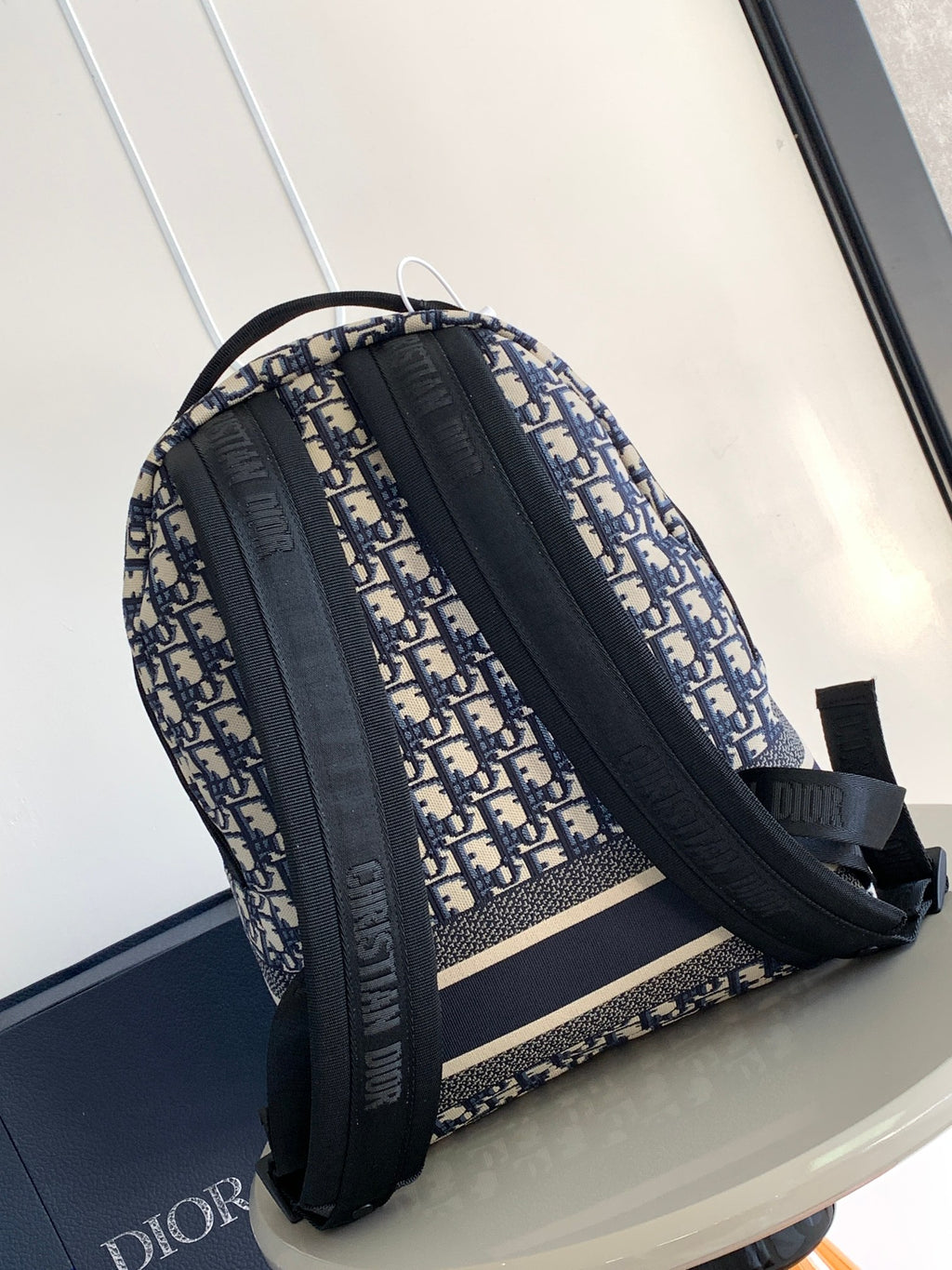 Dior men's backpack side view with two wide black straps and monogram fabric