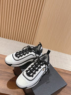 Pair of white and black unisex sneakers on a dark box, lace-up style