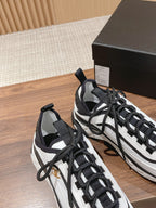 White and black unisex sneakers close-up with black laces and padded collar