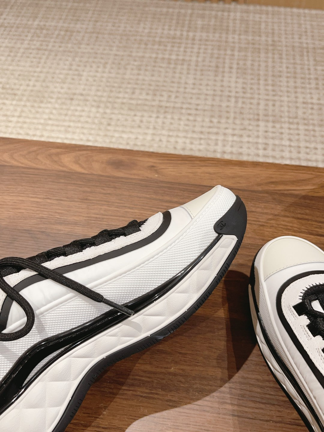 White and black unisex sneaker side profile with black trim and lace-up front