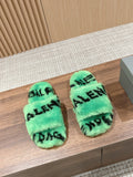 Mint green faux-fur slide sandals with black Balenciaga-style lettering, pair on floor.