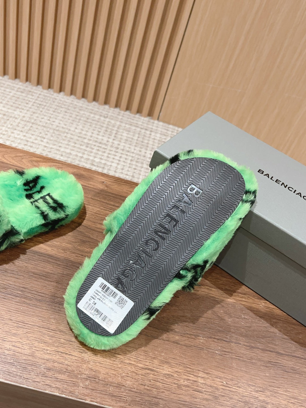 Mint green slide sandal outsole with black pattern and Balenciaga-style branding, rear view.