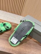 Mint green slide sandal outsole with black pattern and Balenciaga-style branding, rear view.