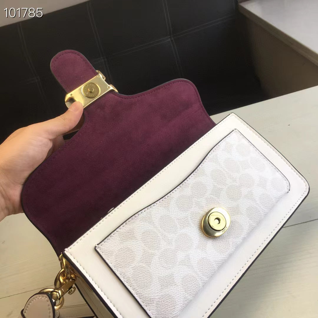 Coah bag with burgundy suede-like flap and white front panel, gold hardware