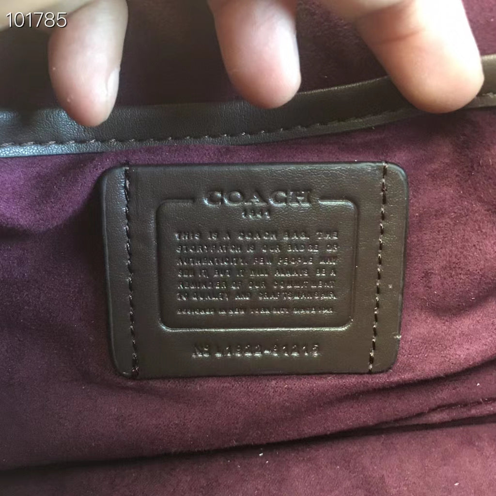 Coah bag leather logo patch on burgundy lining, with embossed text