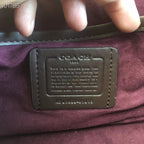 Coah bag leather logo patch on burgundy lining, with embossed text