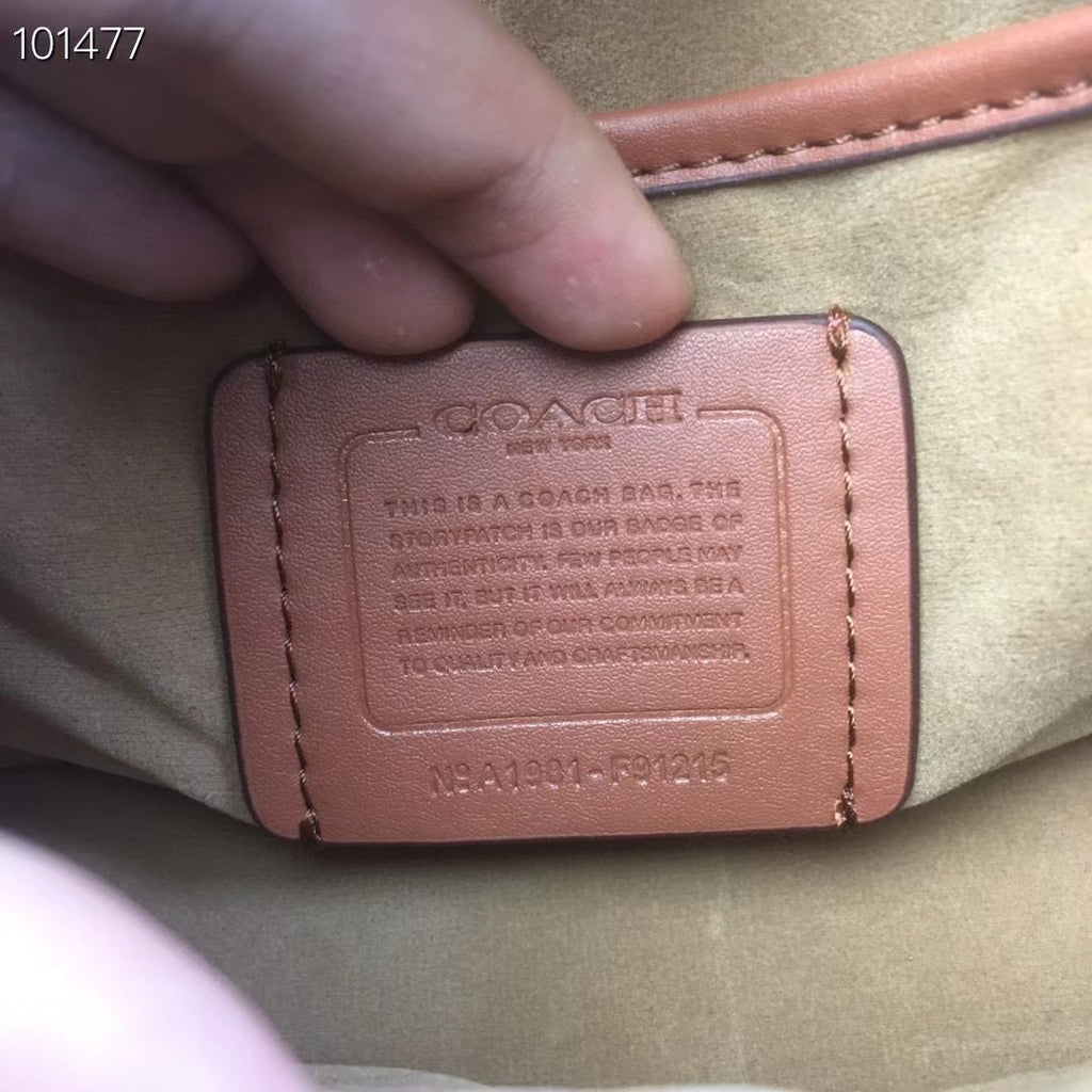 Coah bag embossed leather label on interior base, tan panel with stitching edges.
