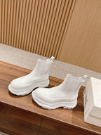 White Chelsea boots on display, slip-on ankle height with elastic gore and chunky sole