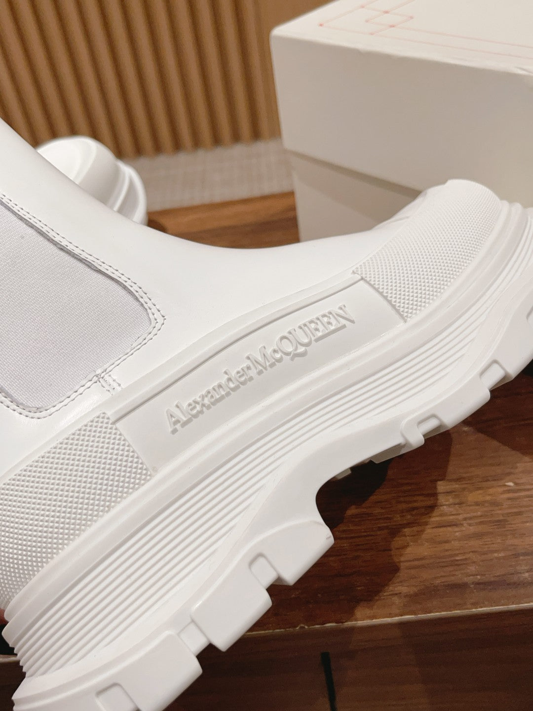 White Chelsea boot side close-up with Alexander McQueen logo on the sole edge