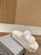 White shearling slide sandals with red logo stripe on the strap, side view