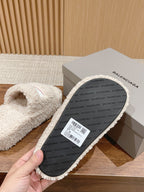 White shearling slide sandal sole with printed Balenciaga branding, side view