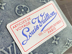 Louis Vuitton luggage label patch with blue script text on denim-style fabric