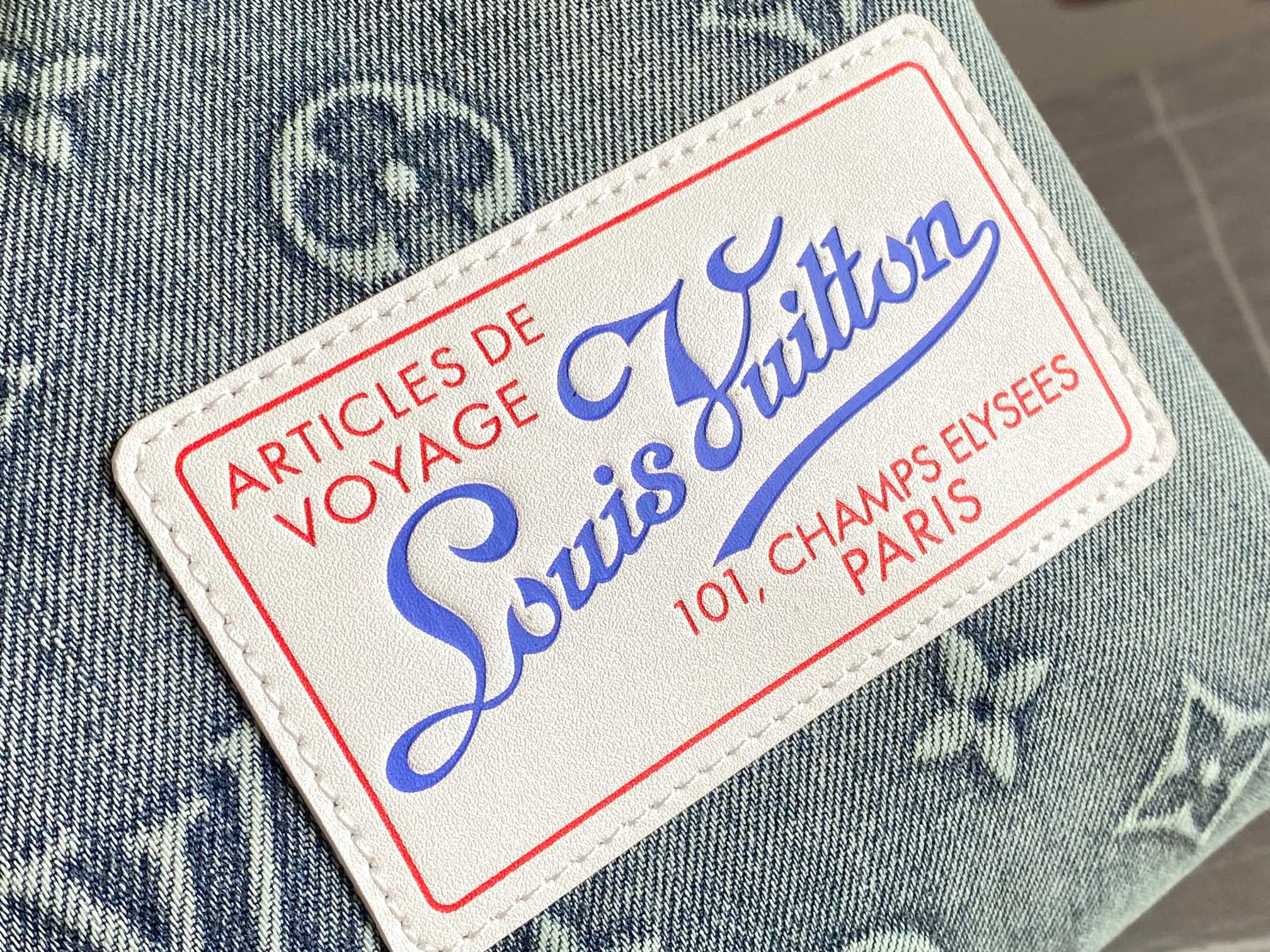 Louis Vuitton luggage label patch on blue fabric, red border and blue logo text