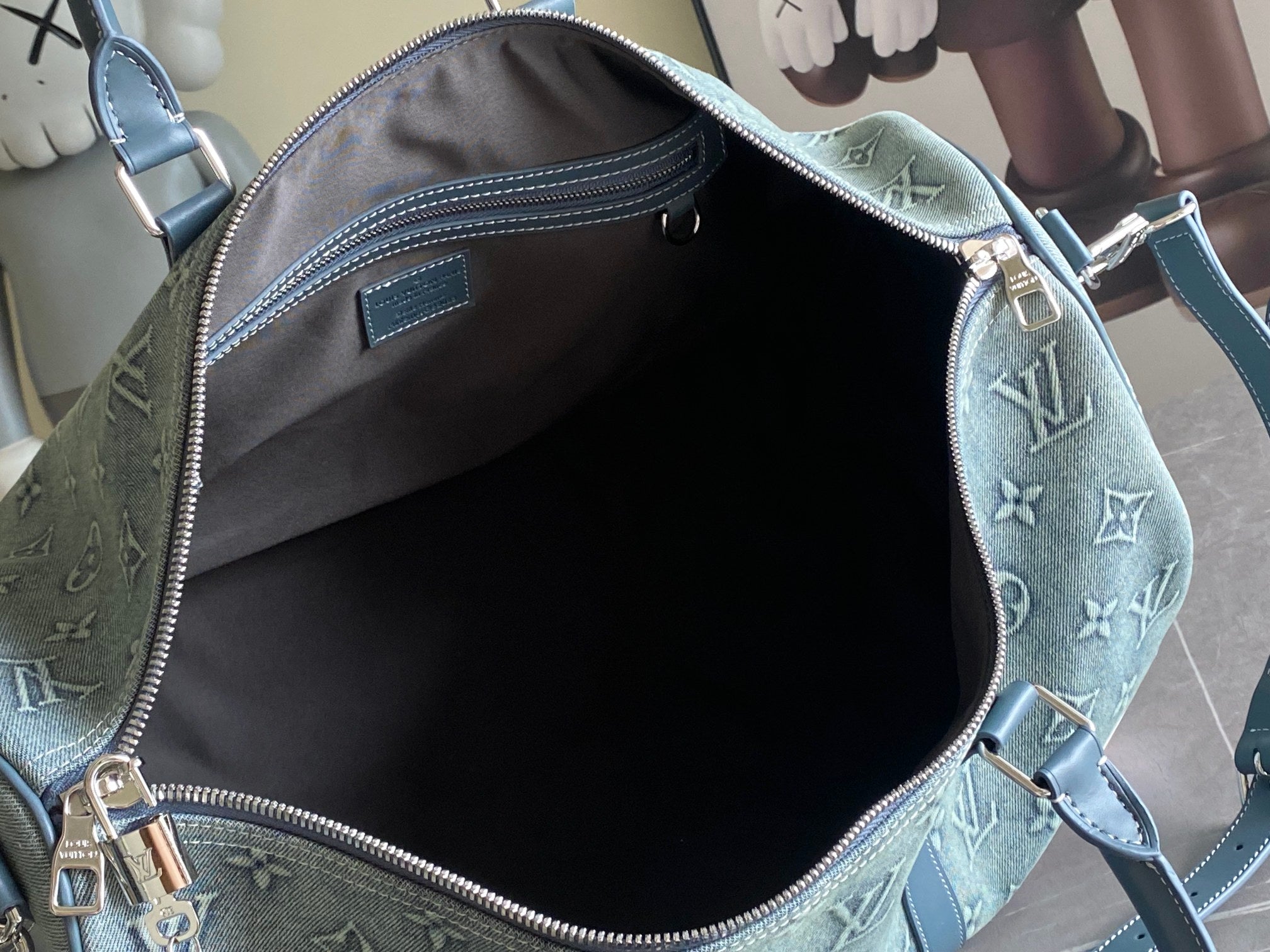 Louis Vuitton duffel bag open interior view with blue-gray monogram trim and zipper top