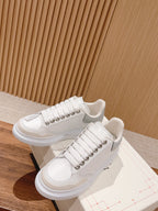 White Alexander McQueen sneakers, lace-up with studded detailing and thick sole