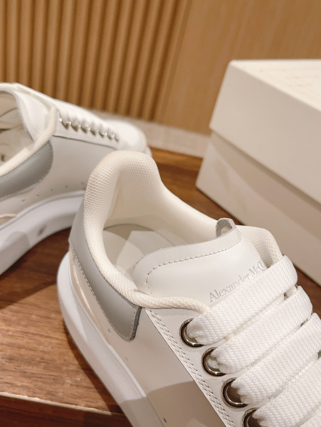 Close-up of white Alexander McQueen sneaker tongue and laces with logo patch