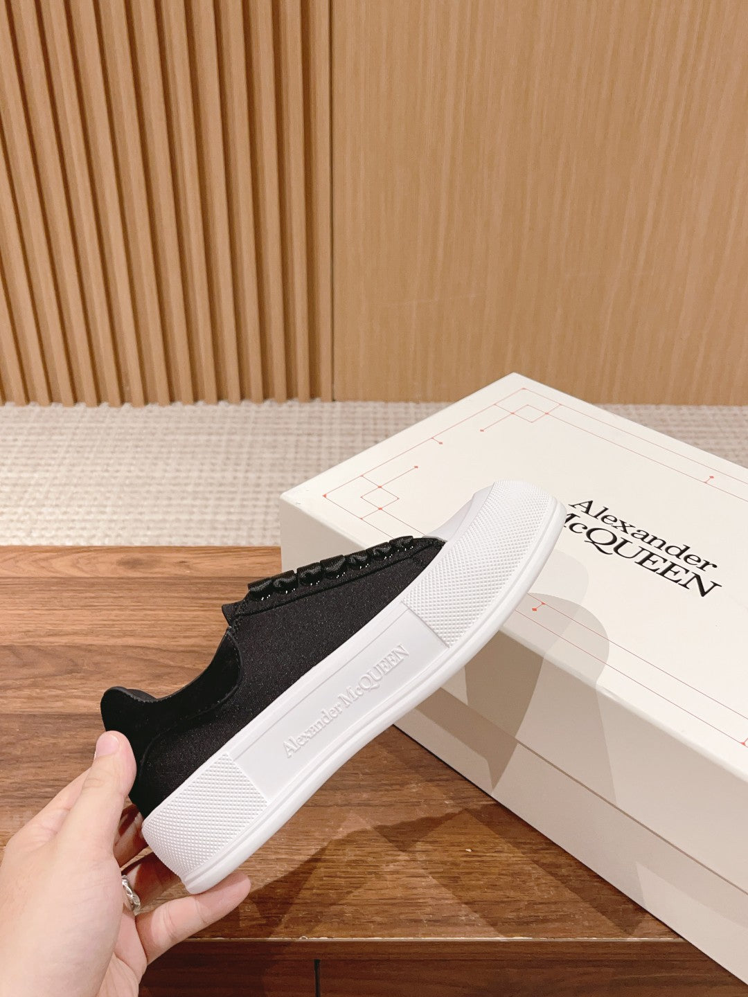 Black Alexander McQueen sneaker, white rubber sole, textured upper with studded side detail