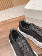 Black fabric sneakers with thick textured sole and lace-up panel with eyelets