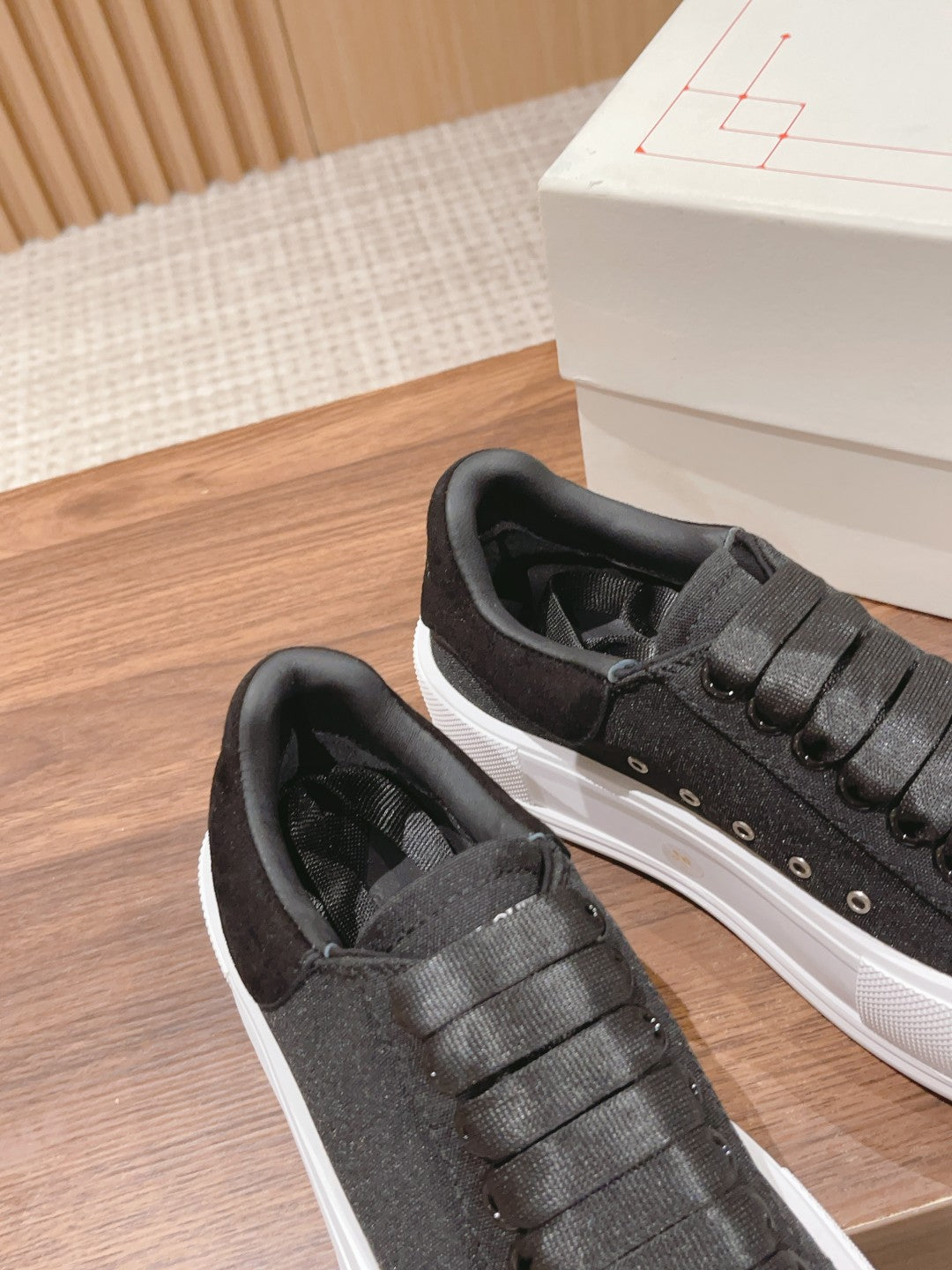 Black fabric sneakers with thick textured sole and lace-up panel with eyelets